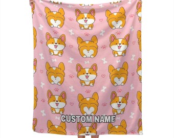 Könnte beinhalten: Rosa Decke mit einem sich wiederholenden Muster aus Cartoon-Corgi-Hunden, Pfotenabdrücken und Knochen. Die Corgis sind orange und weiß. Die Decke hat unten den Text "CUSTOM NAME".