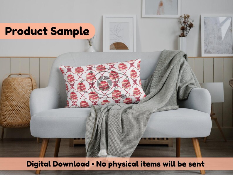 May include: A decorative rectangular pillow with a repeating pattern of red cakes on a white background, accented with a red geometric design. The pillow is placed on a light gray sofa with a gray blanket.