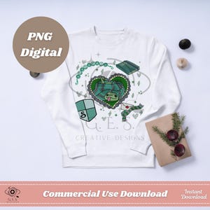Może przedstawiać: Biała bluza z zielono-szarym wzorem węża w sercu. Projekt zawiera tarczę z literą "S", książkę i szalik. Słowa "PNG Digital" znajdują się w okręgu po lewej stronie.