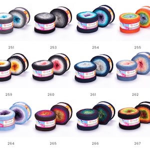 May include: Assortment of yarn balls in various color combinations, including grey, blue, orange, and brown. Each ball has a label with the text "YarnArt" and a number.