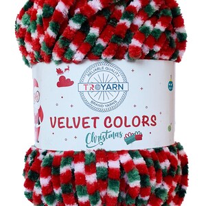 Może przedstawiać: Motka czerwonej, zielonej i białej przędzy welurowej z tekstem "RELIABLE QUALITY" i "TROYARN BRAND YARNS" na etykiecie. Etykieta zawiera r&oacute;wnież napis "VELVET COLORS Christmas".