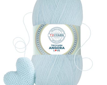 May include: A skein of light blue yarn with a label that reads "Troyarn Angora Love" and a small crocheted heart made from the yarn.