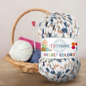 Może przedstawiać: Motka niebieskiej, białej i brązowej przędzy o aksamitnej fakturze. Przędza jest oznaczona "TROYARN" i "VELVET COLORS".