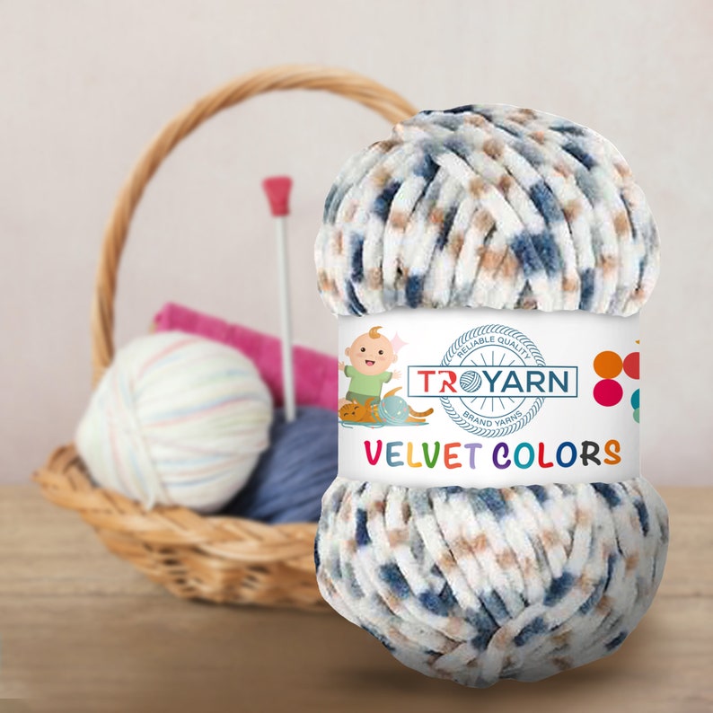 Może przedstawiać: Motka niebieskiej, białej i brązowej przędzy o aksamitnej fakturze. Przędza jest oznaczona "TROYARN" i "VELVET COLORS".