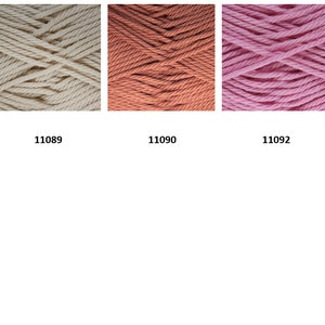May include: Six skeins of yarn in various colors, including red, white, peach, pink, and orange. The yarn is arranged in a row, with the numbers 11087, 11089, 11090, 11092, 11093, and 11097 printed below each skein.