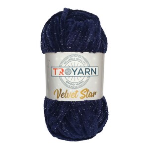 以下が含まれることがあります： 銀色のグリッターがついたネイビーブルーの糸の玉。ラベルには「TROYARN Brand Yarns Velvet Star」と赤い星と白い背景が書かれている。