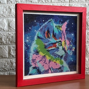 May include: A framed diamond painting of a colorful cat with a galaxy background. The frame is red.