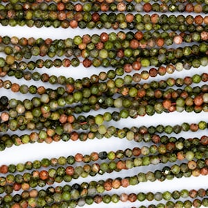 Puede incluir: Una hebra de cuentas de piedras preciosas verdes, marrones y rojas. Las cuentas son facetadas y tienen un aspecto moteado.