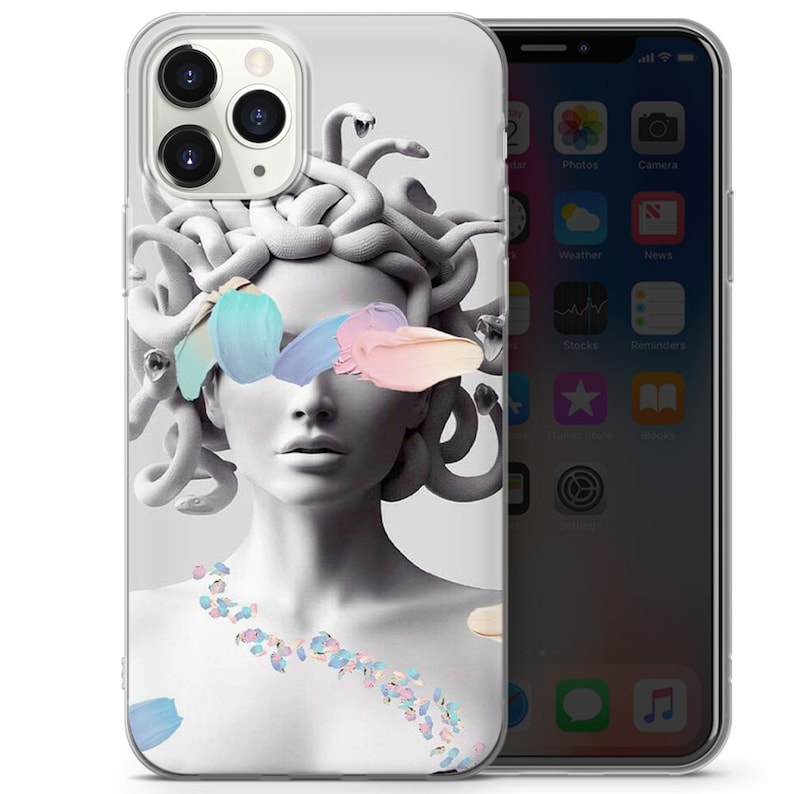 May include: A clear phone case featuring a graphic of Medusa, a Greek mythological figure with snakes for hair, with colourful paint strokes covering her eyes. The background is white.