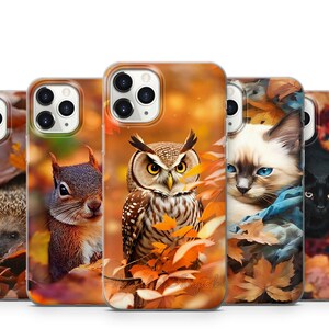 May include: Four different phone cases with autumn-themed designs. The cases feature a hedgehog, a squirrel, an owl, and a cat. The cases are all white with a clear back and have a fall foliage design.