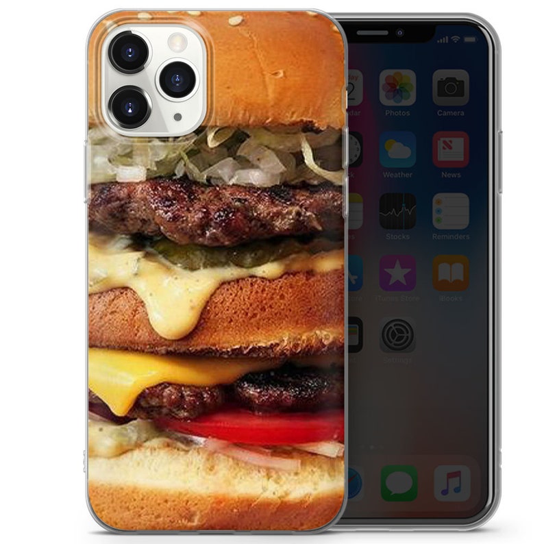 May include: A clear phone case featuring a photograph of a large, double-decker hamburger. The hamburger has two beef patties, cheese, lettuce, tomato, pickles, and a sesame seed bun.