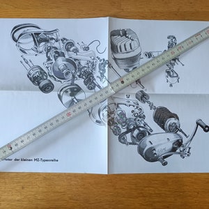 Pode incluir: Um diagrama explodido de um motor de motocicleta, com vários componentes rotulados e separados. Uma régua de madeira, com aproximadamente 120 cm de comprimento, está colocada sobre o diagrama. O texto "motor der kleinen MZ-Typenreihe" é visível.
