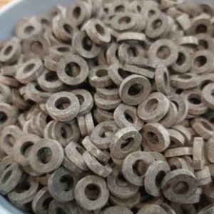 Könnte beinhalten: Nahaufnahme einer hellblauen Schüssel, gefüllt mit zahlreichen grauen, ringförmigen Objekten. Es handelt sich vermutlich um Unterlegscheiben, jede mit einem kreisförmigen Loch. Die Unterlegscheiben sind gestapelt und gehäuft.