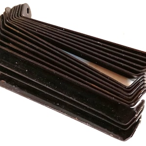 May include: A stack of black metal brackets, each with a right-angle bend and a mounting hole. The brackets are arranged in a fan shape, showing their individual forms and the overall quantity.