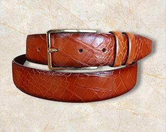 Cinto artesanal de couro castanho claro de 35 mm com padrão de crocodilo e fivela dourada.