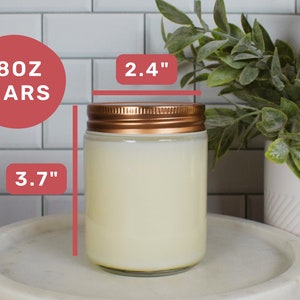 May include: A clear glass candle jar with a copper lid. The jar is filled with a white candle wax. The jar is 3.7 inches tall and 2.4 inches wide. The jar is labeled "8oz Jars".