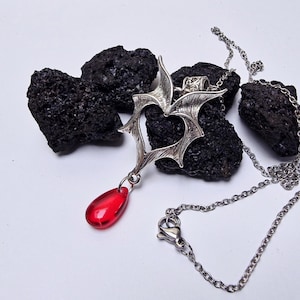 Heart-shaped bat wing necklace: romantic vampire gothic pendant with dangling red glass blood drop on a stainless steel chain