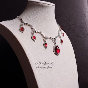 May include: A set of three ceramic mugs with a speckled, cream-colored glaze. Each mug features a different hand-painted floral design in shades of blue, green, and yellow. The mugs have a simple, rounded shape and a comfortable handle.