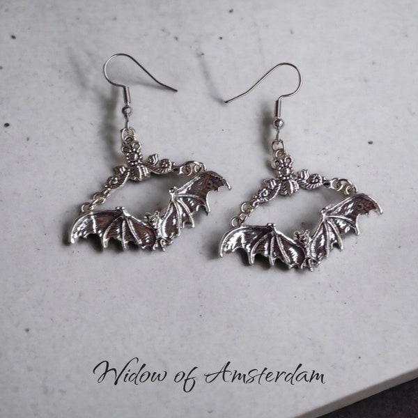 Zilverkleurige vliegende vleermuizen, bungelende vleermuis oorbellen aan antiek stijl ornamentjes - Vampire Widow of Amsterdam