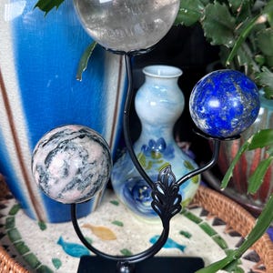 Black metal sphere stand with leaf holds three spheres