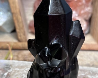 Black obsidian carved into a crystal point cluster
