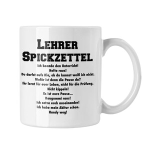 Könnte beinhalten: Weiße Keramik-Tasse mit dem schwarzen Text "LEHRER SPICKZETTEL" und mehreren Zeilen deutschen Textes. Die Tasse hat einen gebogenen Henkel und ist für heiße oder kalte Getränke geeignet.