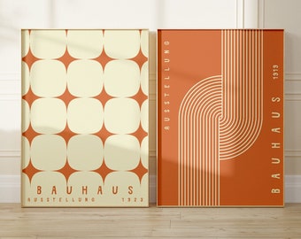 May include: Two framed prints with a geometric design. The print on the left has a pattern of white squares with rounded corners on an orange background. The print on the right has a pattern of orange and white stripes on an orange background. Both prints have the text "BAUHAUS AUSSTELLUNG" and a year, 1923 and 1919, respectively.