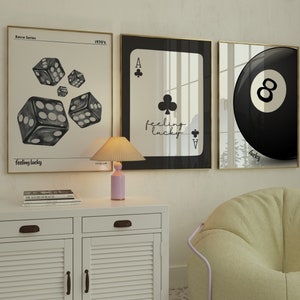 May include: Three framed prints with a retro theme. The first print features a set of dice with the text "feeling lucky" and "1970's". The second print features a playing card, the Ace of Clubs, with the text "feeling lucky". The third print features a black and white 8-ball with the text "lucky".