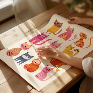 May include: A colorful illustration featuring a variety of cartoon cats in different poses and colors. The cats are depicted with whimsical designs, including stripes, spots, and rainbow accents. The artwork is displayed on a light-colored paper, creating a playful and artistic aesthetic.