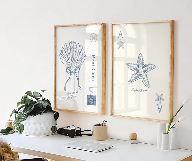 May include: Two framed art prints with beach-themed illustrations. One features a blue seashell with a bow and the text "Meet me at the Beach". The other shows a blue starfish and the text "Bonjour for ever".