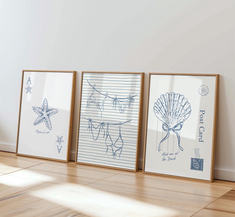 May include: Three framed art prints with beach-themed illustrations. One features a starfish and playing card symbols, another shows a clothesline with swimwear, and the last depicts a seashell with text that reads "Meet me at the Beach."