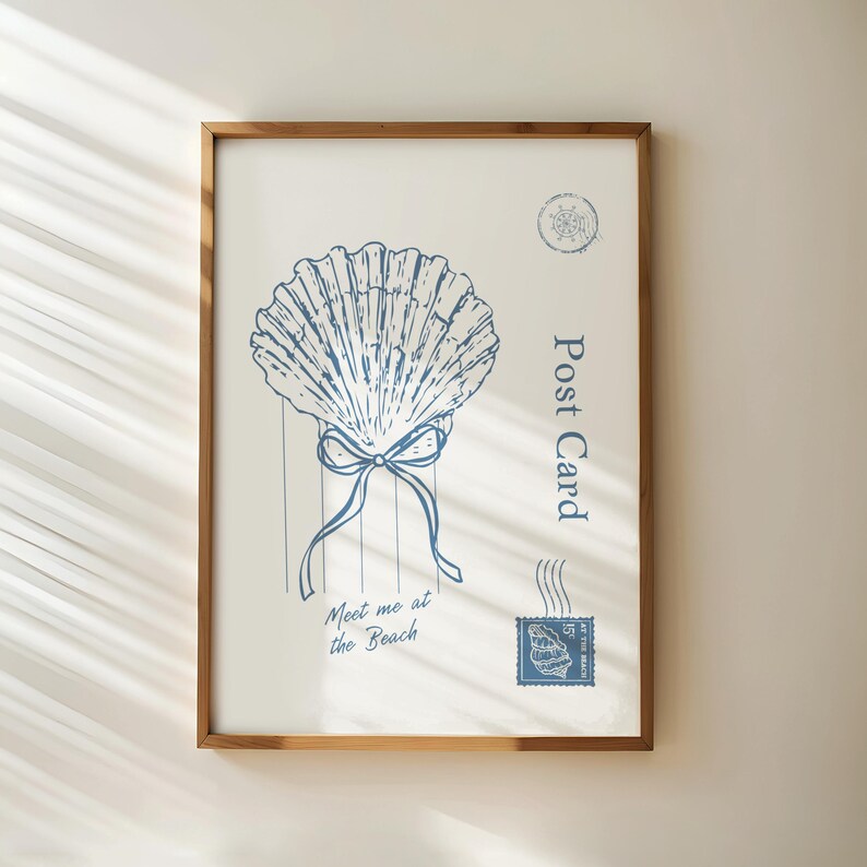 May include: A framed print featuring a blue seashell design with a bow and the text "Meet me at the Beach." The word "Post Card" is printed vertically on the right side. A postage stamp and other nautical elements complete the design.