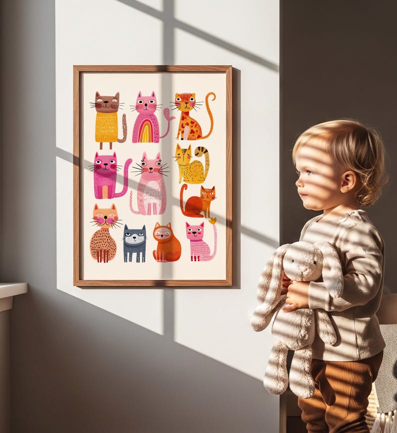 May include: A framed art print featuring a collection of colorful, stylized cat illustrations. The cats are depicted in various poses and colors, including orange, pink, yellow, and blue, against a cream background. The frame is a light brown wood.