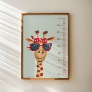 May include: A framed wall art print featuring a giraffe illustration. The giraffe wears sunglasses and a red bandana. A red height chart is on the right side of the image, with measurements in centimetres. The background is a light blue colour.