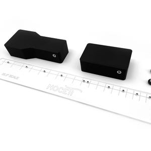May include: A set of black plastic blocks with a clear plastic ruler with the text "SELF SCALE" and "NOCETI" printed on it. Two silver screws are also included.