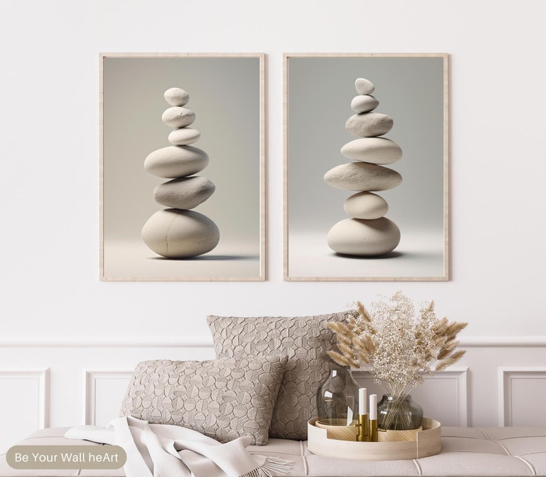 Puede incluir: Dos impresiones de arte de pared minimalistas que presentan piedras blancas apiladas en una disposici&oacute;n zen. Las impresiones est&aacute;n enmarcadas en un marco de madera claro y tienen un fondo blanco.