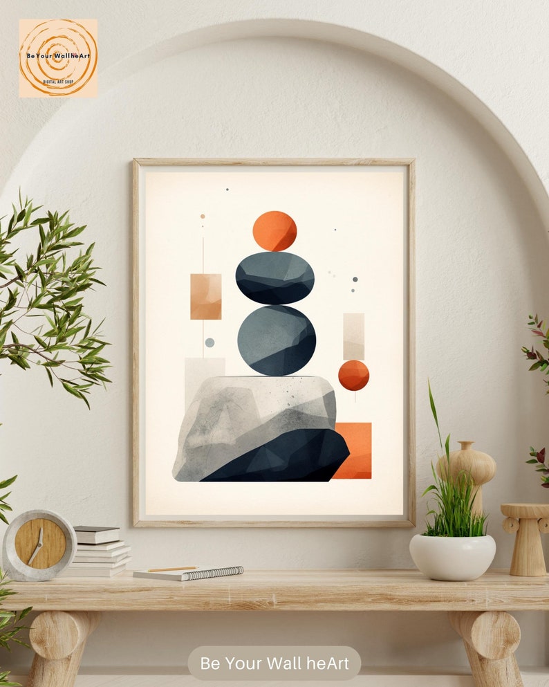 May include: Abstract geometric wall art print featuring a stack of blue and gray stones with orange circles on a beige background. The print is framed and hanging on a white wall.