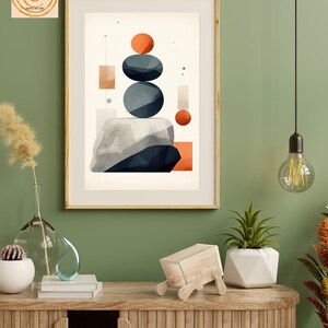 May include: Abstract geometric art print with a stack of blue and orange shapes on a white background. The print is framed in a light wood frame and hanging on a green wall. The text "Be Your Wall heArt" is visible at the bottom of the image.