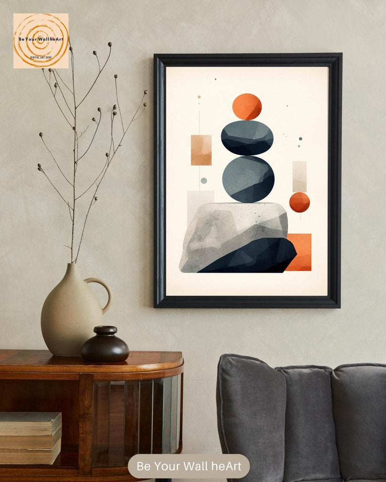 May include: Abstract geometric art print with a white background, featuring stacked blue and gray circles, orange and red squares and rectangles, and a gray and white rock-like shape at the bottom. The print is framed in black.