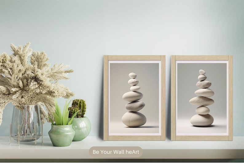 Puede incluir: Dos impresiones enmarcadas de piedras apiladas en un estilo minimalista. Las impresiones est&aacute;n en marcos de madera y tienen un fondo gris claro.