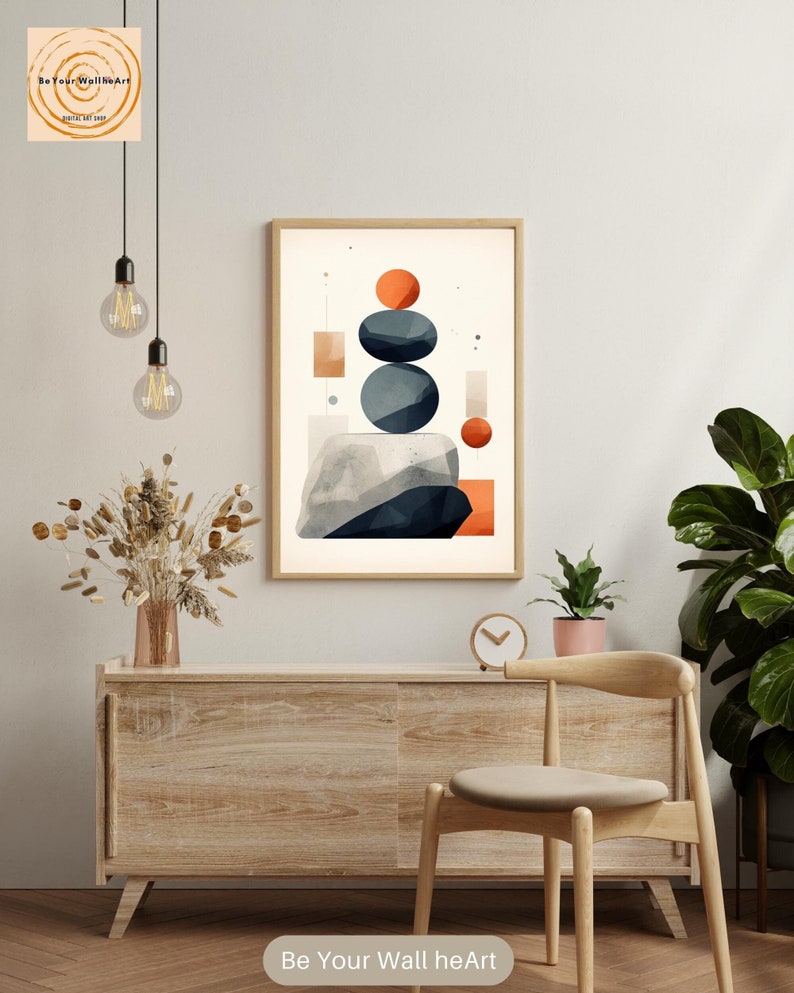 May include: Abstract geometric wall art print with a stacked arrangement of blue and orange circles on a white background. The print is framed in a light wood frame and is hanging on a white wall above a wooden dresser and chair.