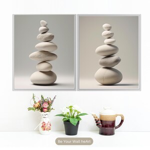 Puede incluir: Dos impresiones enmarcadas de piedras blancas apiladas sobre un fondo blanco. Las impresiones son de estilo minimalista y presentan una est&eacute;tica zen.