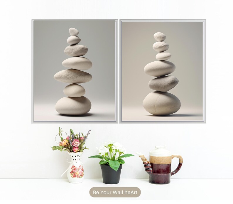 Puede incluir: Dos impresiones enmarcadas de piedras blancas apiladas sobre un fondo blanco. Las impresiones son de estilo minimalista y presentan una est&eacute;tica zen.