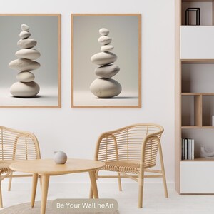 Puede incluir: Dos impresiones enmarcadas de piedras blancas apiladas sobre un fondo gris claro. Las impresiones est&aacute;n colgadas en una pared blanca sobre una mesa de caf&eacute; de madera y dos sillas de mimbre.