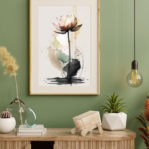 May include: A watercolor painting of a pink lotus flower with green leaves and a brown stem. The painting is framed in a light wood frame and is hanging on a green wall. The painting is surrounded by a variety of home decor items, including a vase with dried flowers, a cactus, a wooden sculpture, and a potted plant.