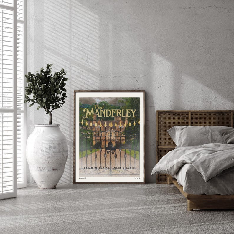 May include: A framed print of a vintage poster with a gold and black design. The poster features a large, ornate gate with a stone building behind it. The text on the poster reads "Visit Manderley, Dream of Coming Again & Again".