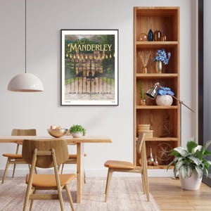 May include: A framed poster with a black frame and a white background. The poster features a photo of a large, old house with a gate in front of it. The text on the poster reads "First Manderley" and "Dream of coming again & again".