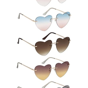 May include: Heart-shaped sunglasses in various colors, including pink, blue, brown, and gray. The lenses have a gradient effect, and the frames are gold-colored. A stylish accessory for any outfit.