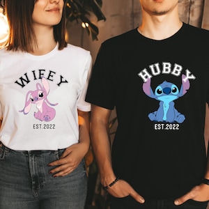 May include: A couple wearing matching t-shirts featuring a cartoon Stitch character. The woman's shirt reads "Wifey Est. 2022" and the man's shirt reads "Hubby Est. 2022".