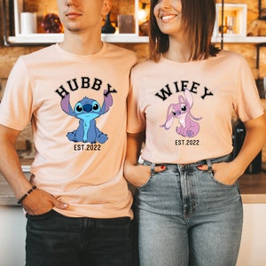 May include: Two peach-coloured t-shirts featuring a cartoon Stitch character. The shirt on the left says "Hubby Est. 2022" and the shirt on the right says "Wifey Est. 2022".